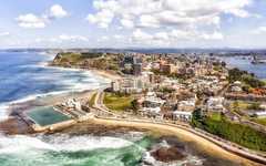 Panorama of Newcastle, NSW city on the hills over Hunter river and Pacific ocean with beaches, pool and surfers.